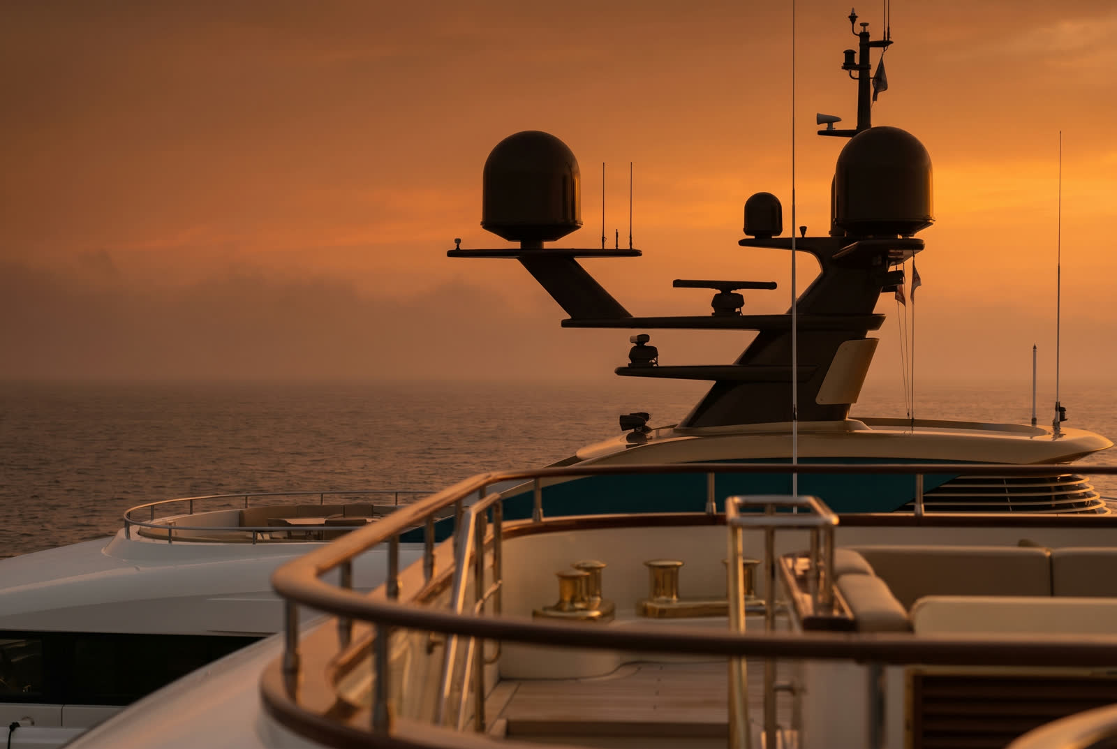 Above-deck satellite domes silhouetted at sunset